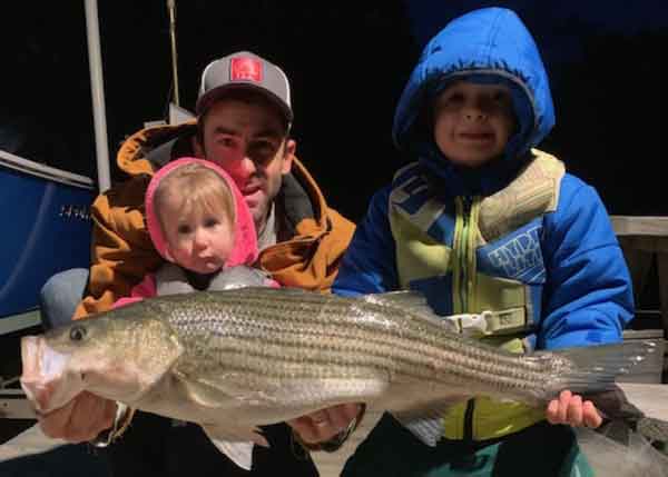 kids with big striper fish