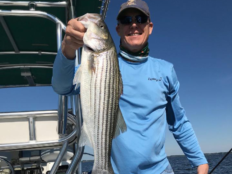 angler holds up a rockfish he caught