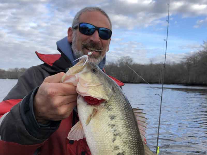 angler holds up a bass