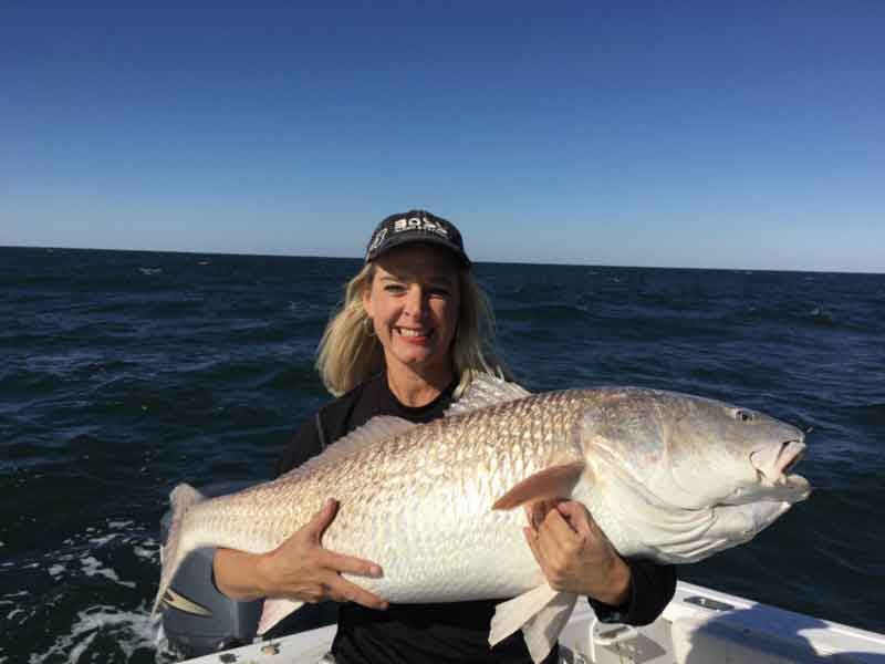 beth holding up a huge redfish