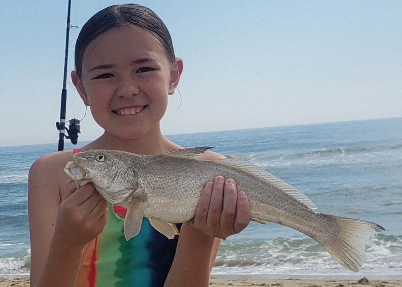 kid holding a kingfish caught surf fishing