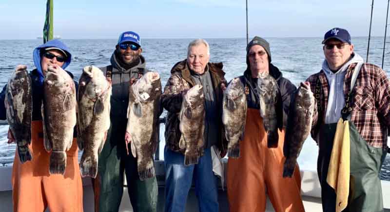 anglers hold up tautog