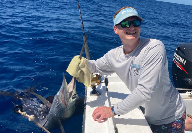 angler holds up a sailfish