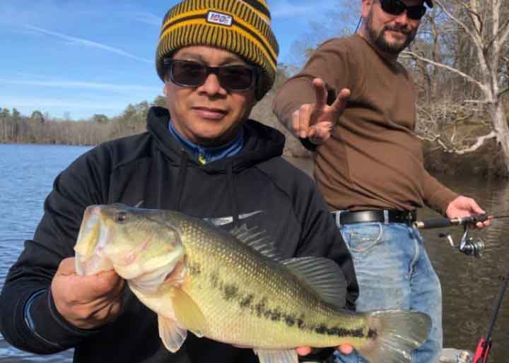 angler holds up a bass