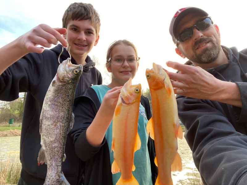 anglers holding up trout