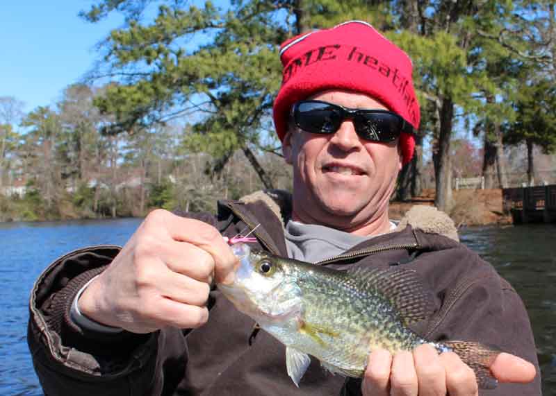 fisherman holds up a crappie fish