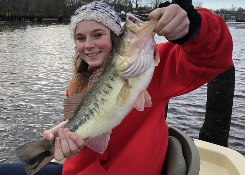 angler with a big bass caught on a bucktail lure