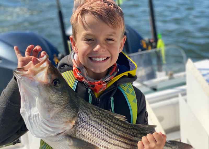 boy with striped bass in the lower chesapeake bay