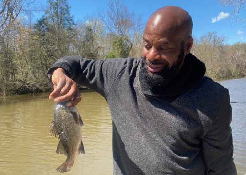 angler fishing the patuxent river holds up a fish
