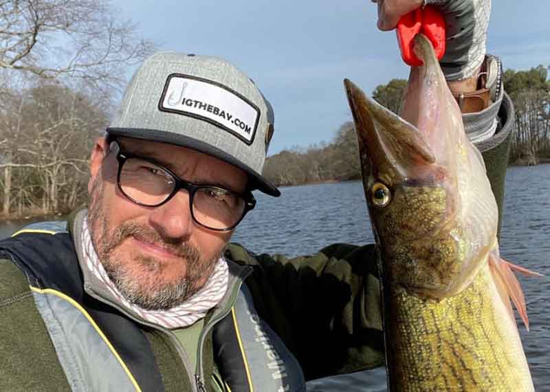 angler holds up a pickerel