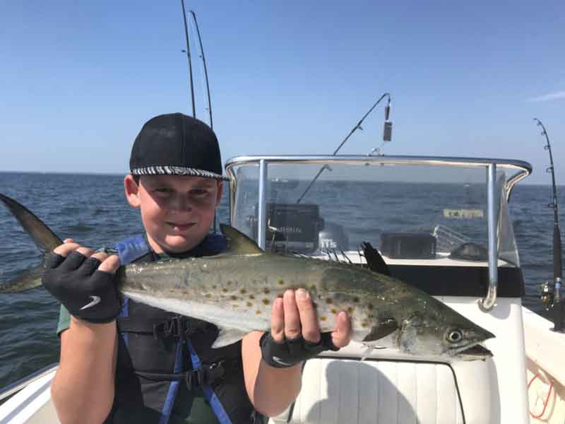 fisherman holding a spanish mackerel