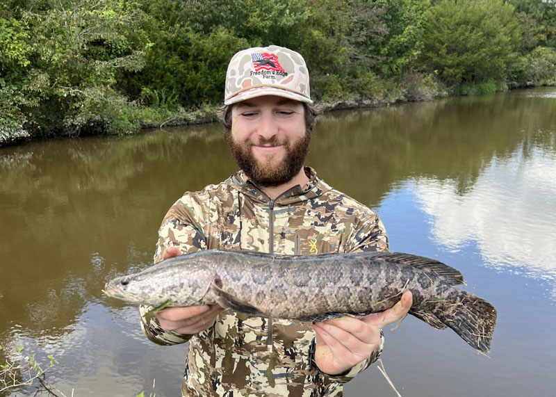 adam with a snakehead he caught fishing the blackwater