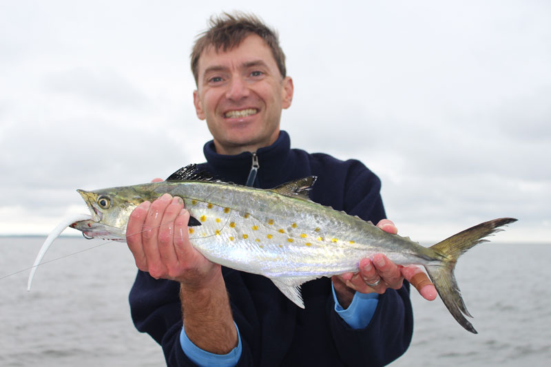 fisherman with a spanish mackerel he caught