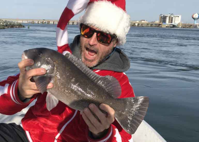 santa fisherman with a tautog