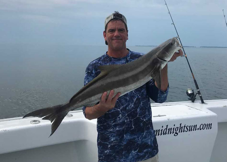 an angler with a cobia he caught